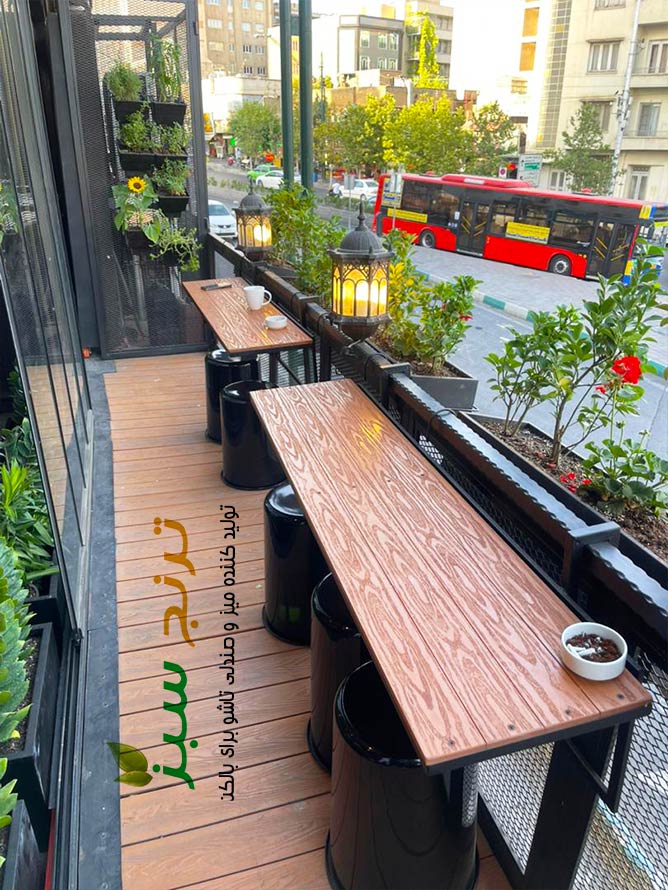 این بالکن کوچک زیبا در شهر تهران قرار دارد و میزهای تاشو آن که از نرده فلزی آویزاست ، با رویه چوب پلاست ضد اب در صنایع ترنج سبز تولید شده است.